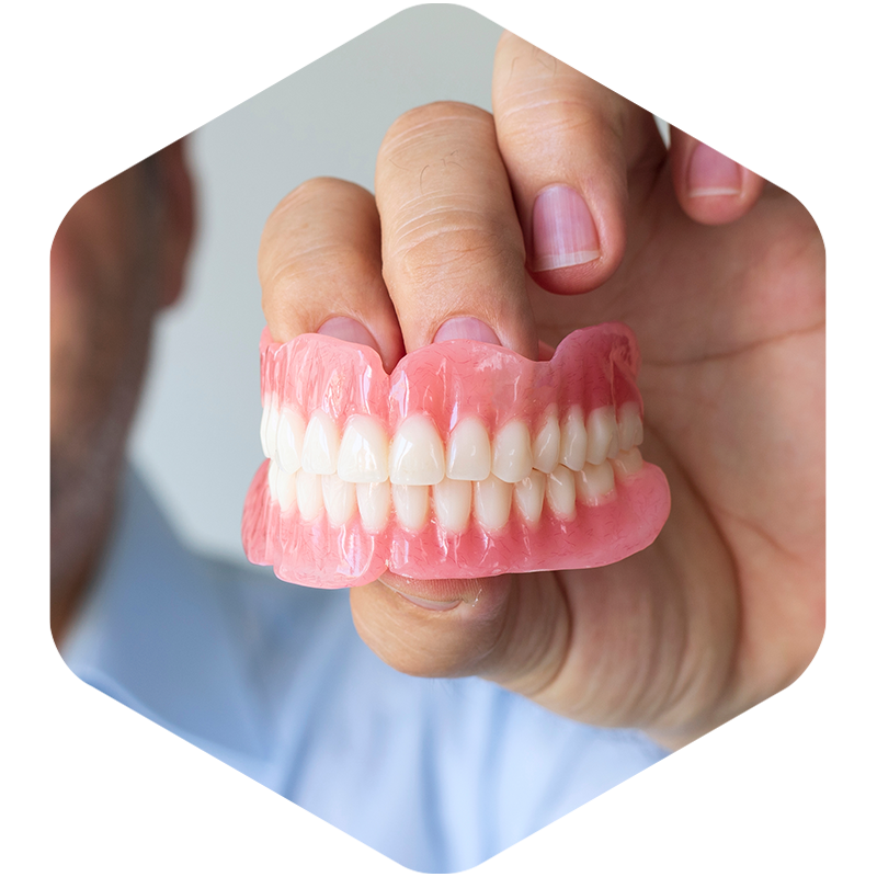 Hand holding a set of dentures.